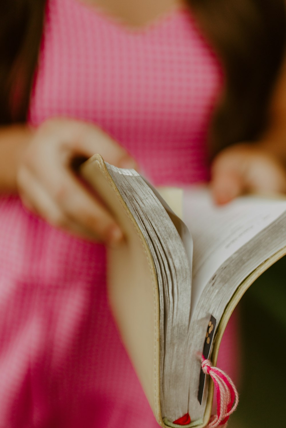 a woman in a pink dress reading a book