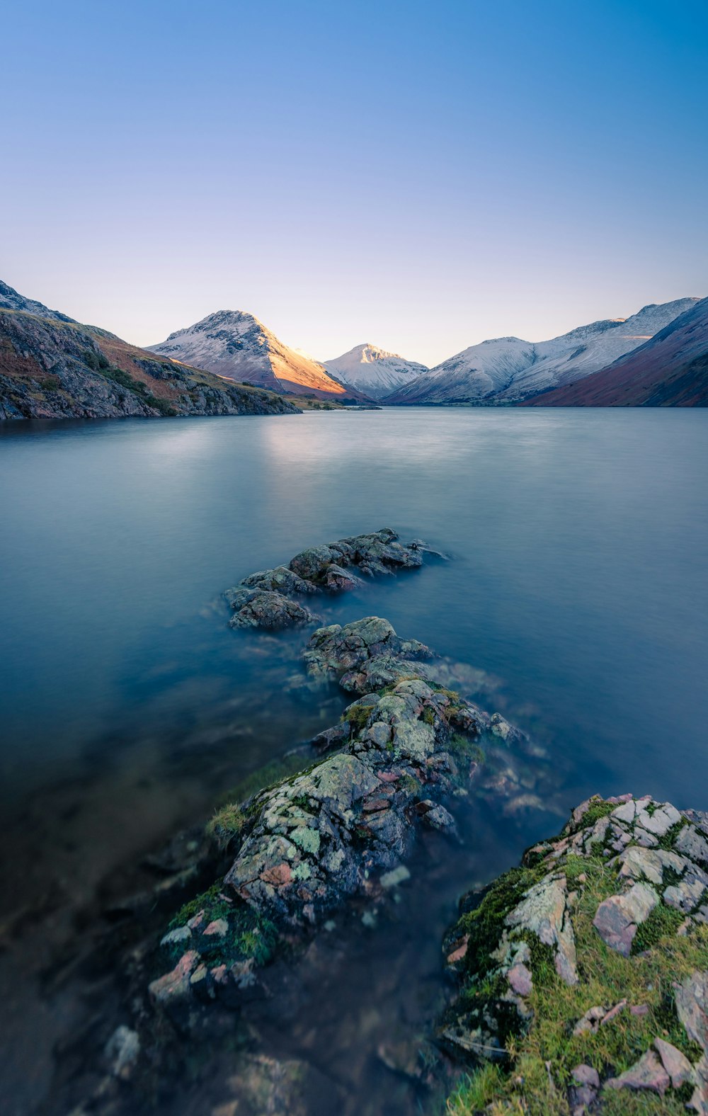 a body of water with mountains in the background