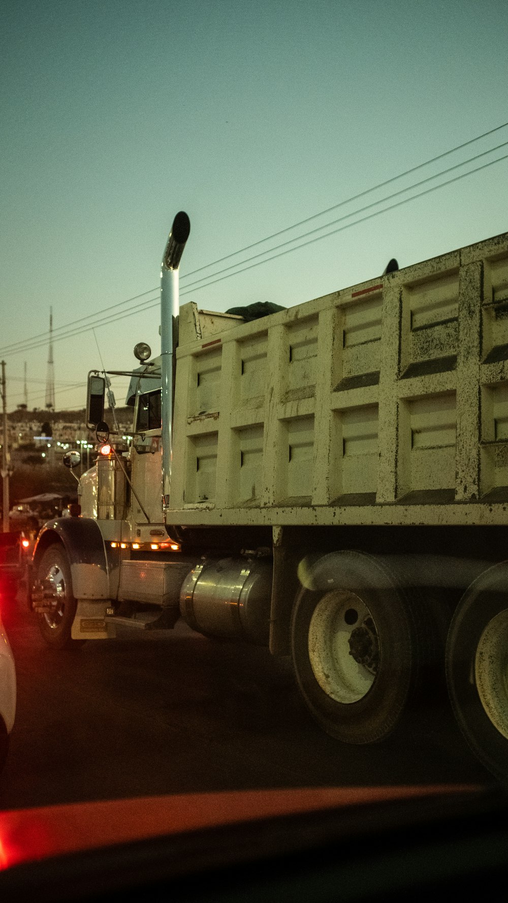 a large truck driving down a street next to a traffic light