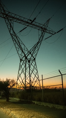 A power transmission tower equipped with zdvolt bushings during sunset, highlighting their durability.