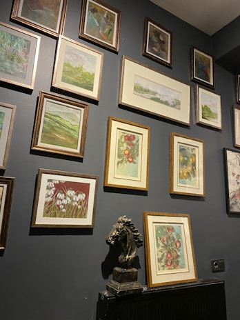 An elegant dark grey and white gallery wall featuring several fine art pieces from dson art gallery.