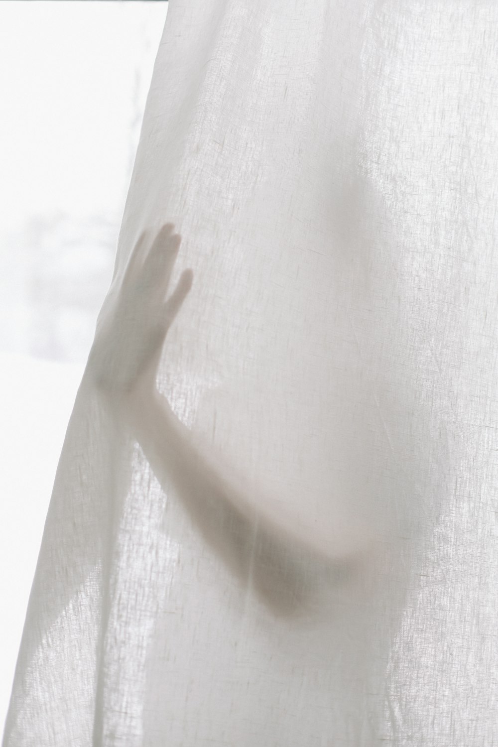 a person's hand coming out of a curtain