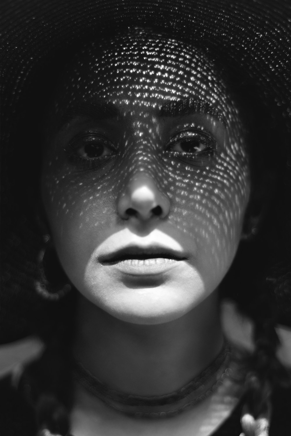 a woman wearing a hat and a necklace