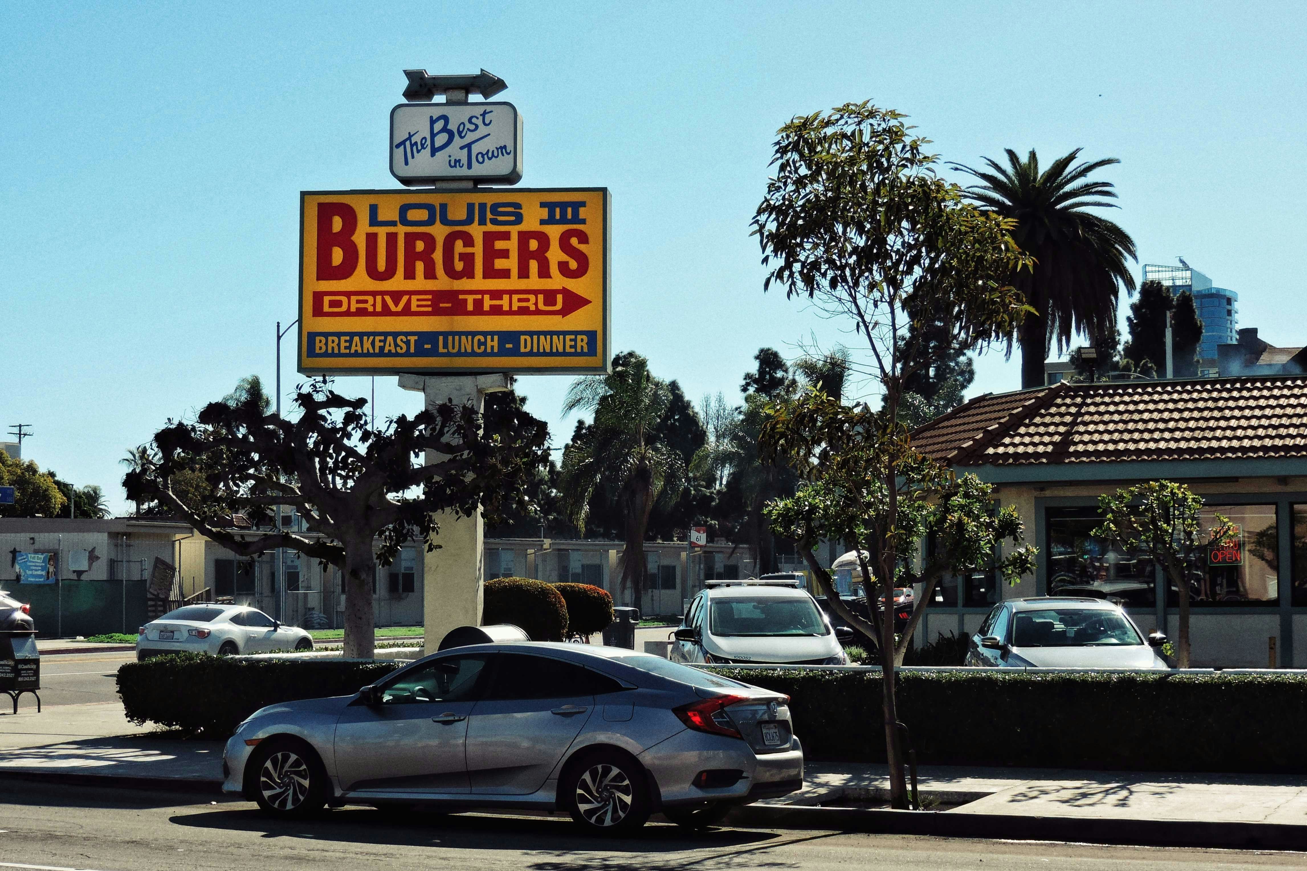 a sign for a burger restaurant on the side of a road