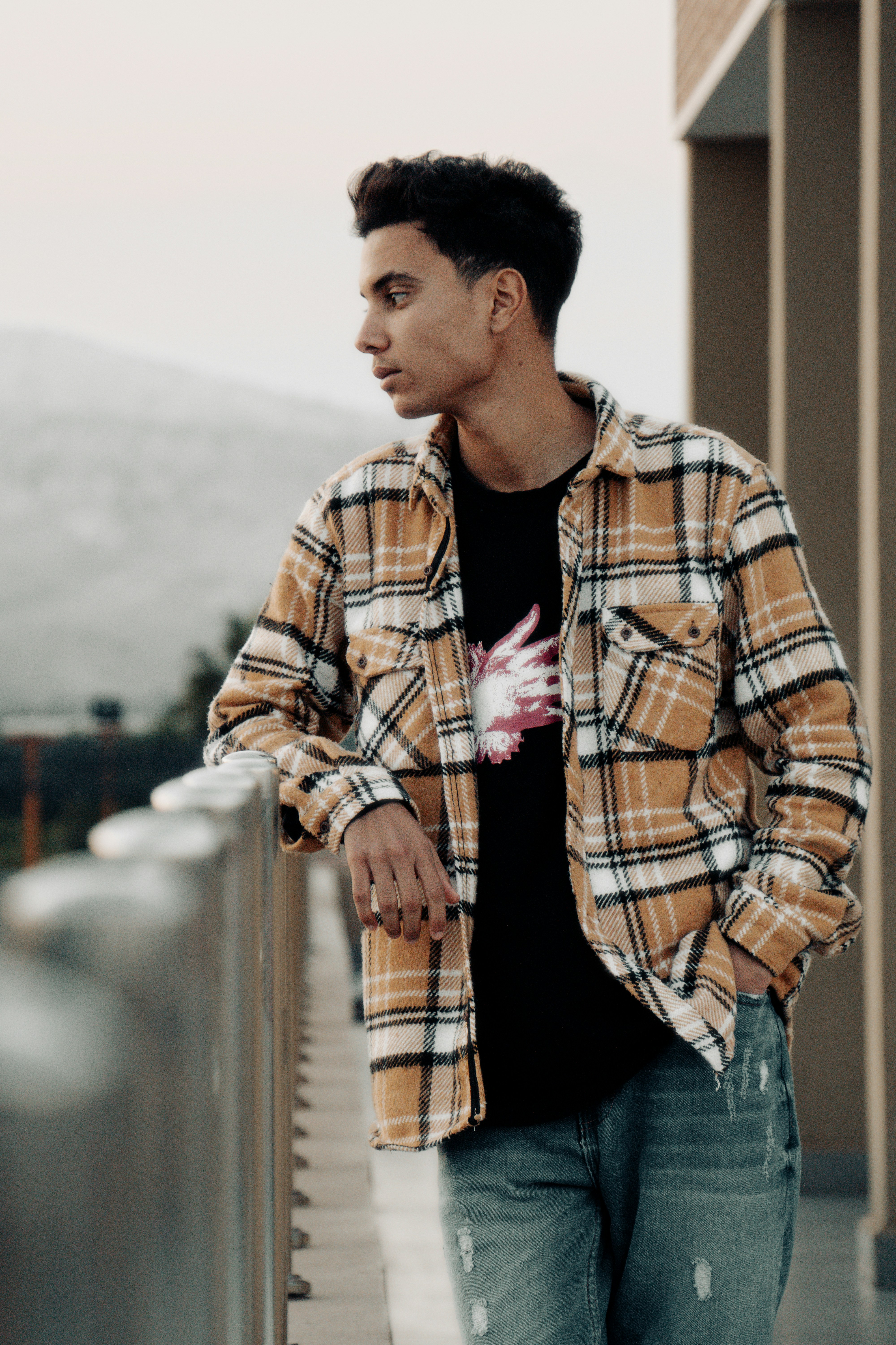 um homem de pé em uma varanda ao lado de um edifício