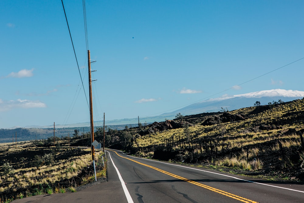 an empty road with a mountain in the background