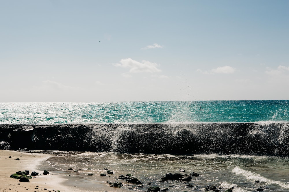 a beach with a wave coming in to the shore