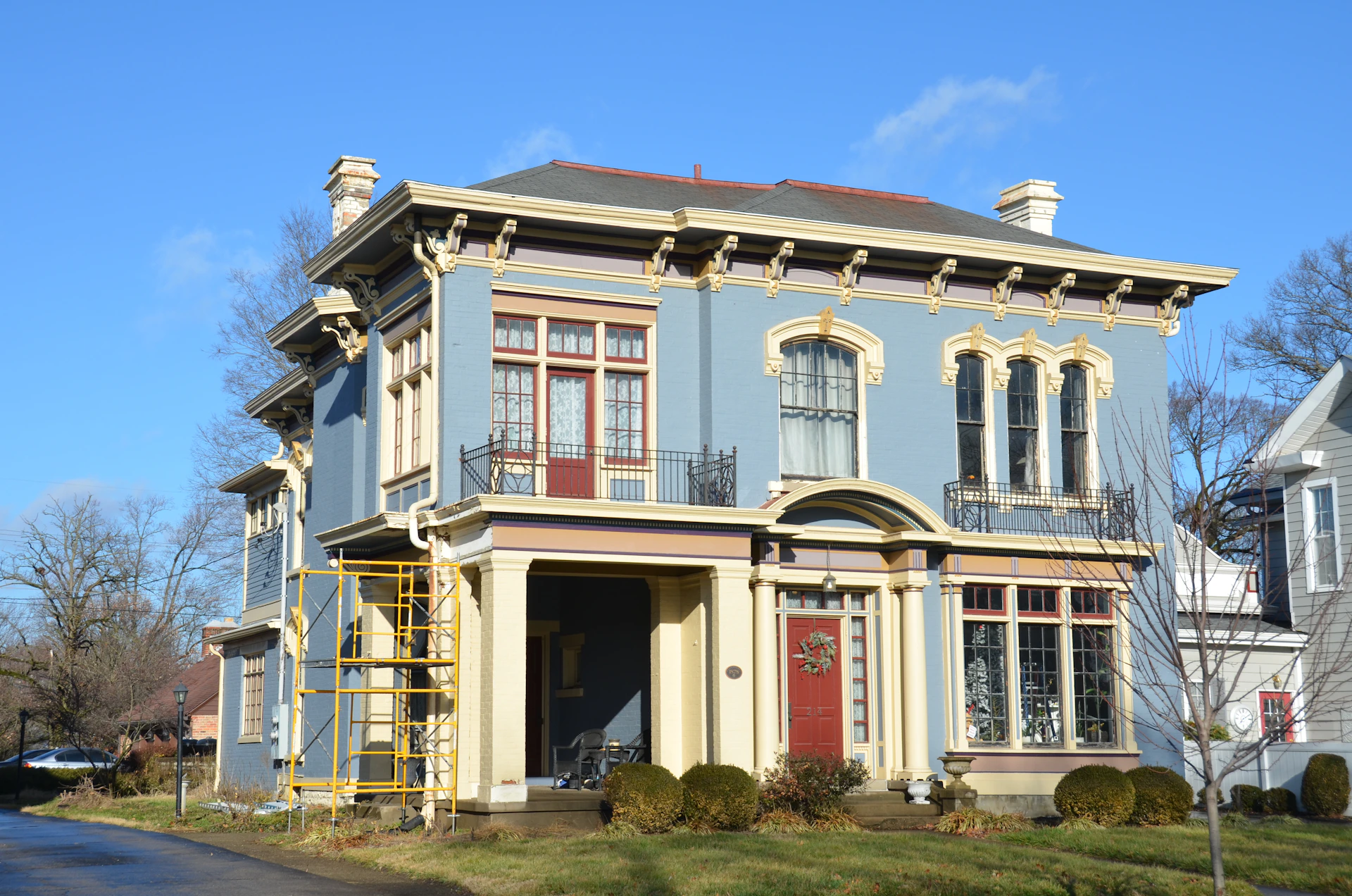 a blue and yellow house with a red door