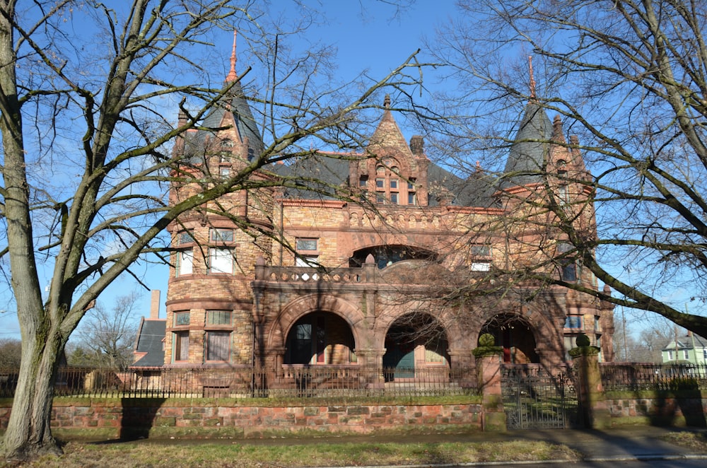 Ein großes Backsteingebäude neben einem Baum