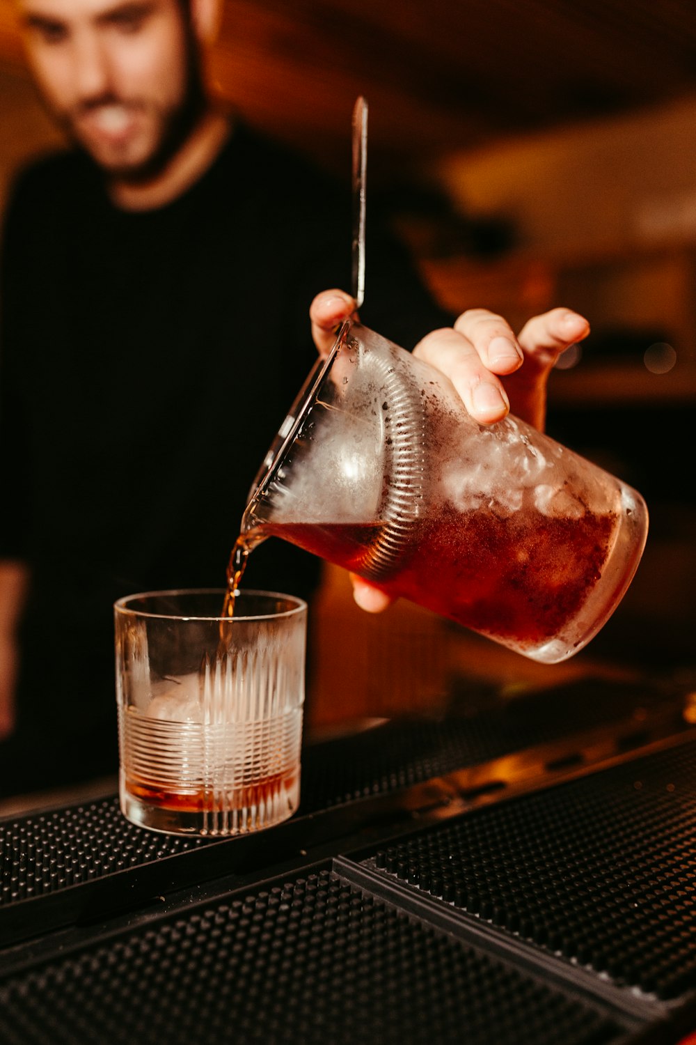 a man pouring a drink into a glass