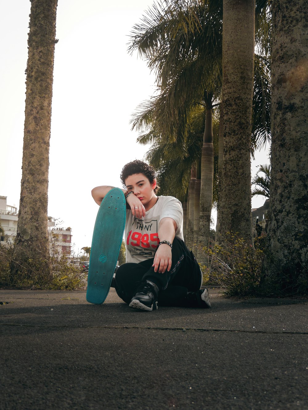 a person sitting on the ground with a skateboard