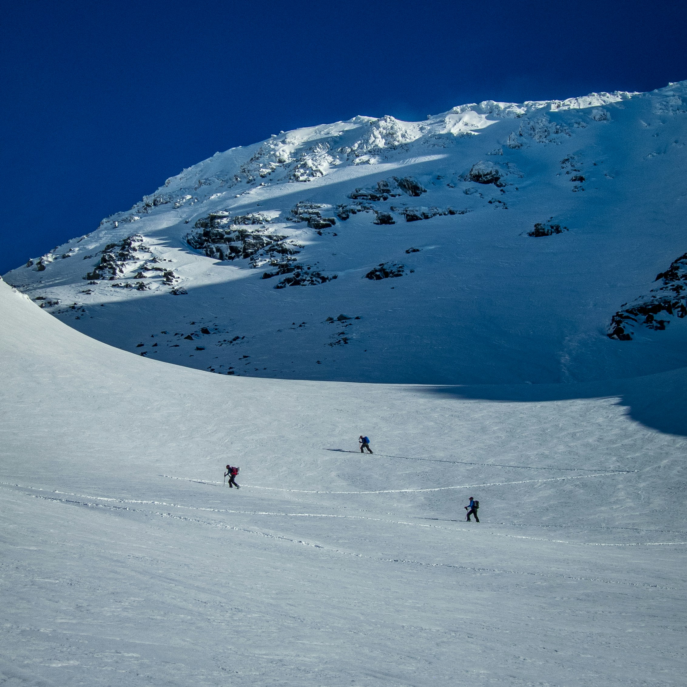 a group of people skiing down a snow covered slope
