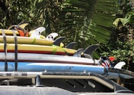 A family loading their car with surfboards, preparing for a safe day of adventure together.