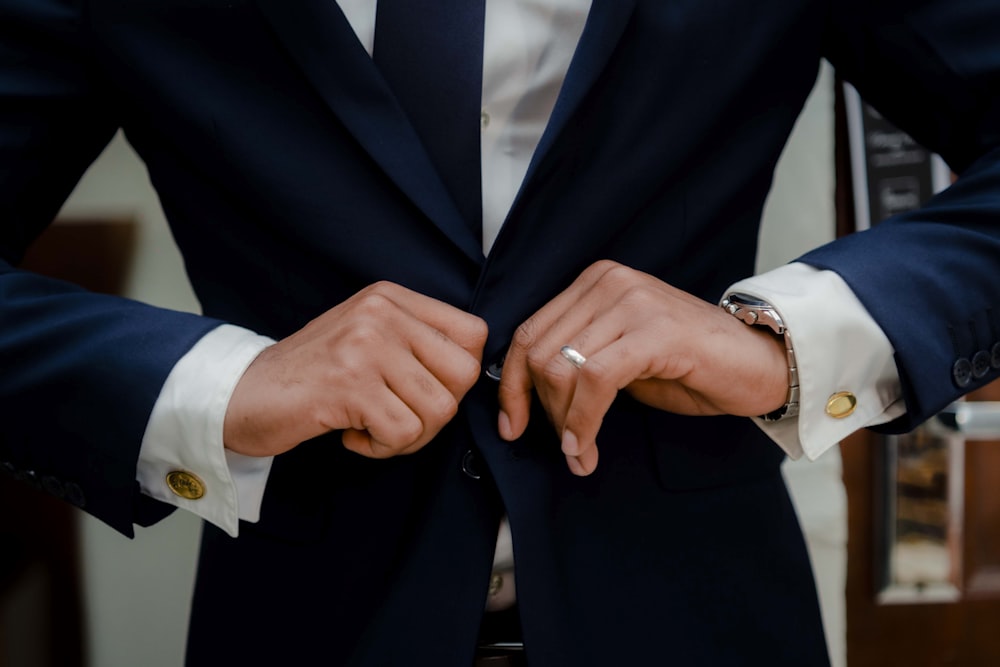 a man in a suit is holding his hands together