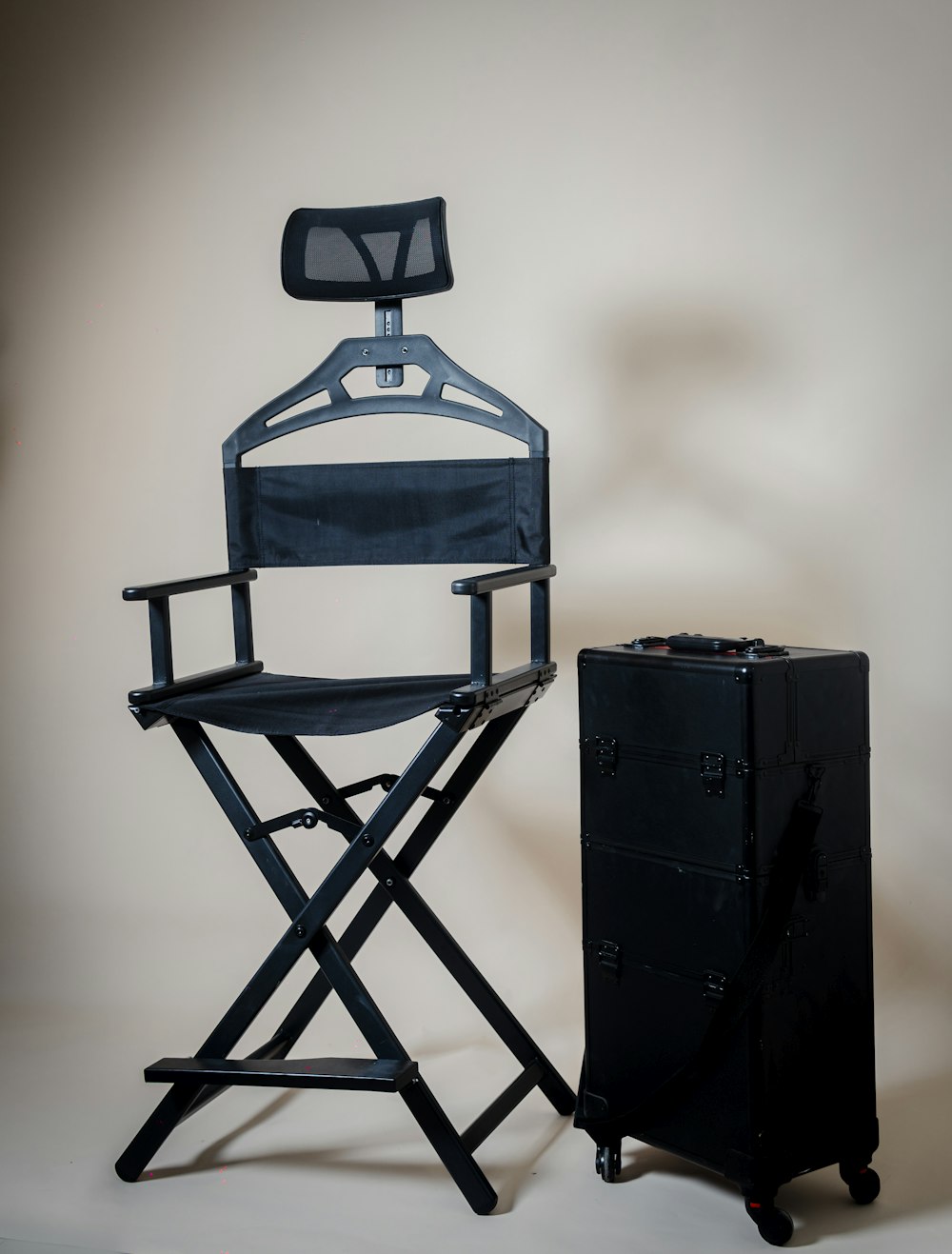 a director's chair next to a black suitcase