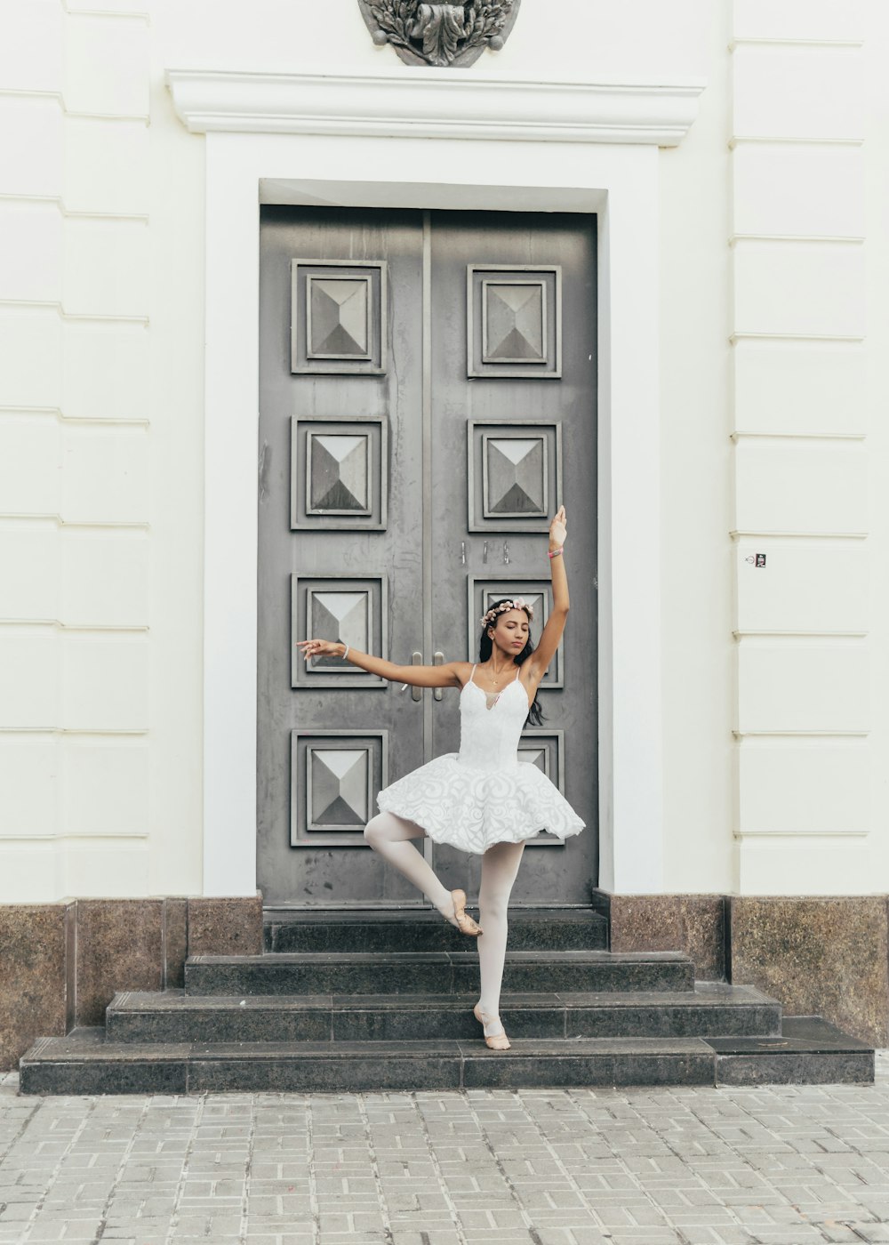 a woman in a white dress standing in front of a door