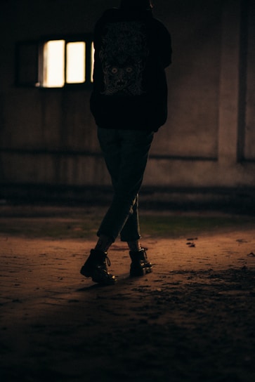 a person standing in the dark with a skateboard
