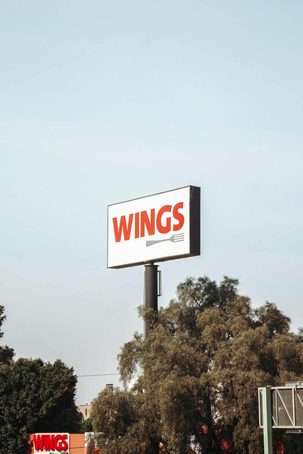a large sign that says wings on the side of a building