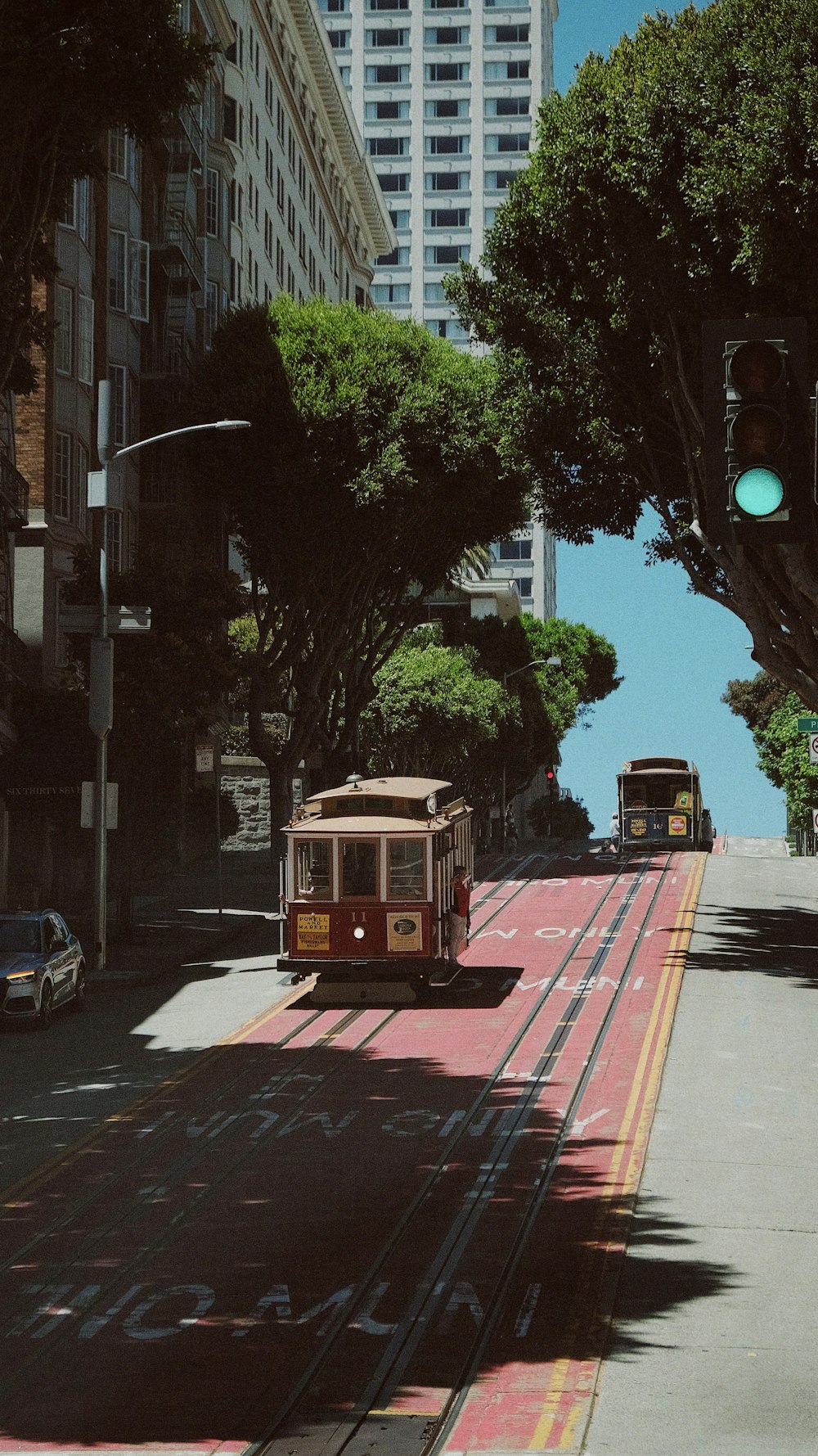 a trolley car traveling down a street next to tall buildings