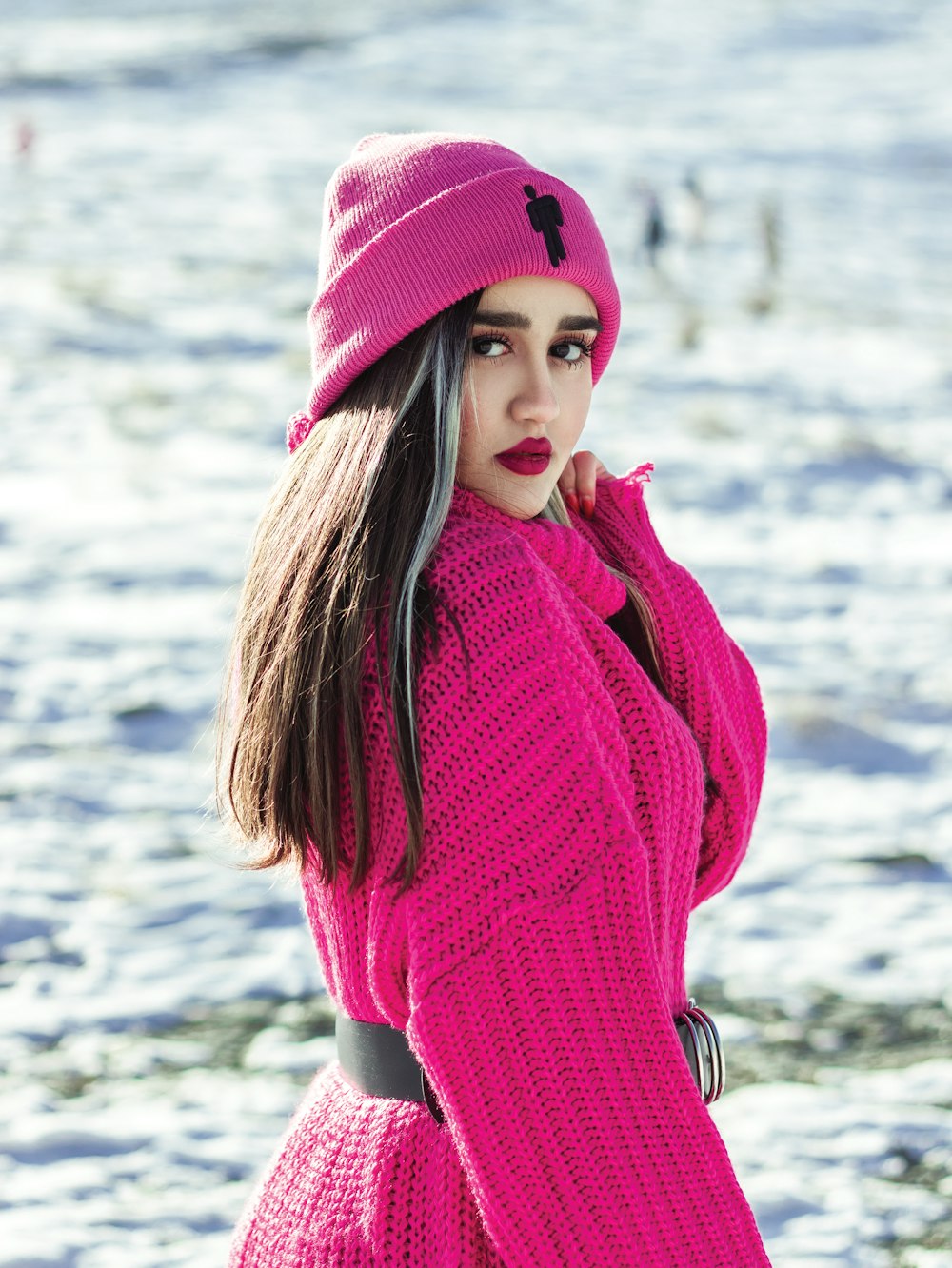 a woman wearing a pink sweater and a pink hat