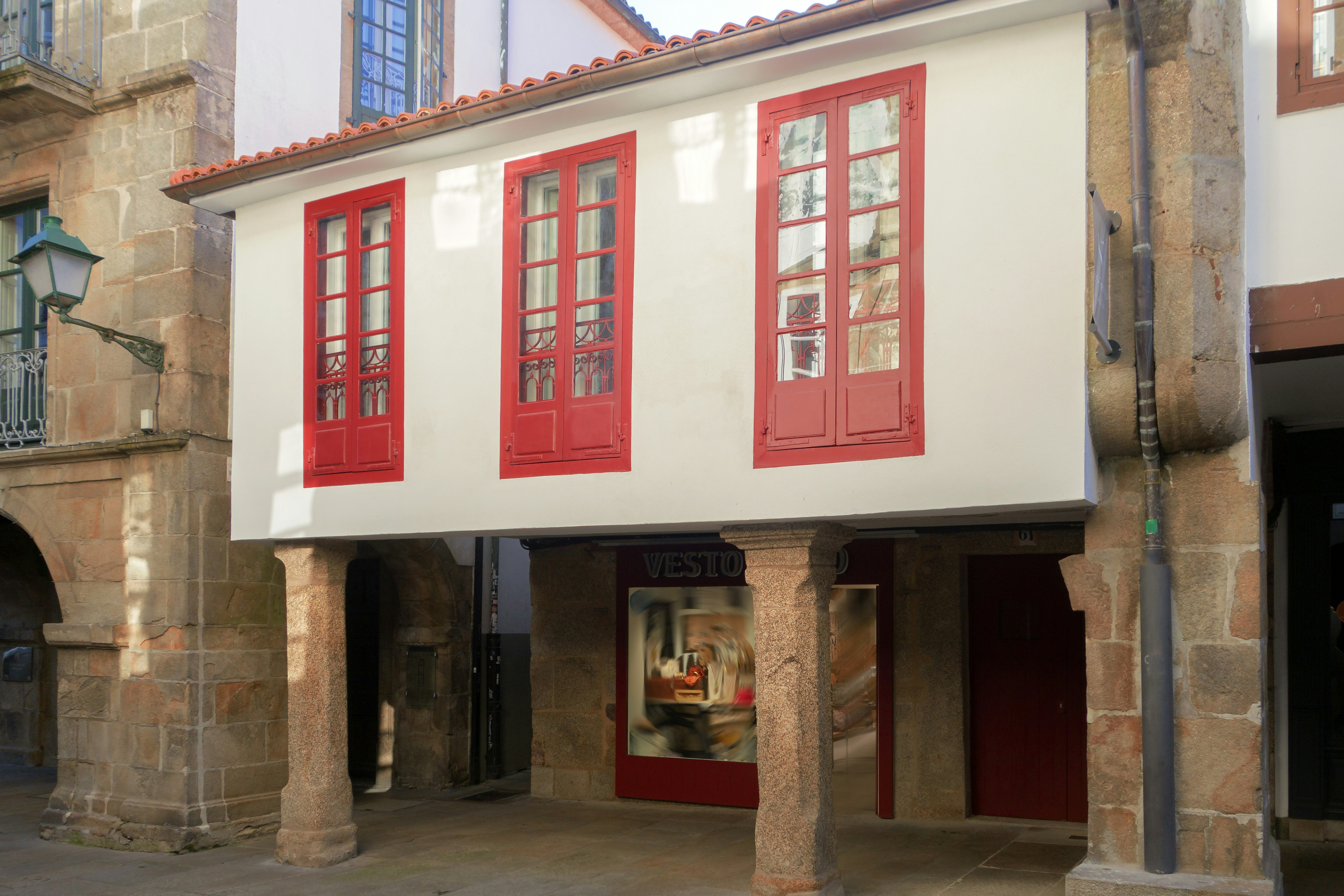 a red and white building with red shutters