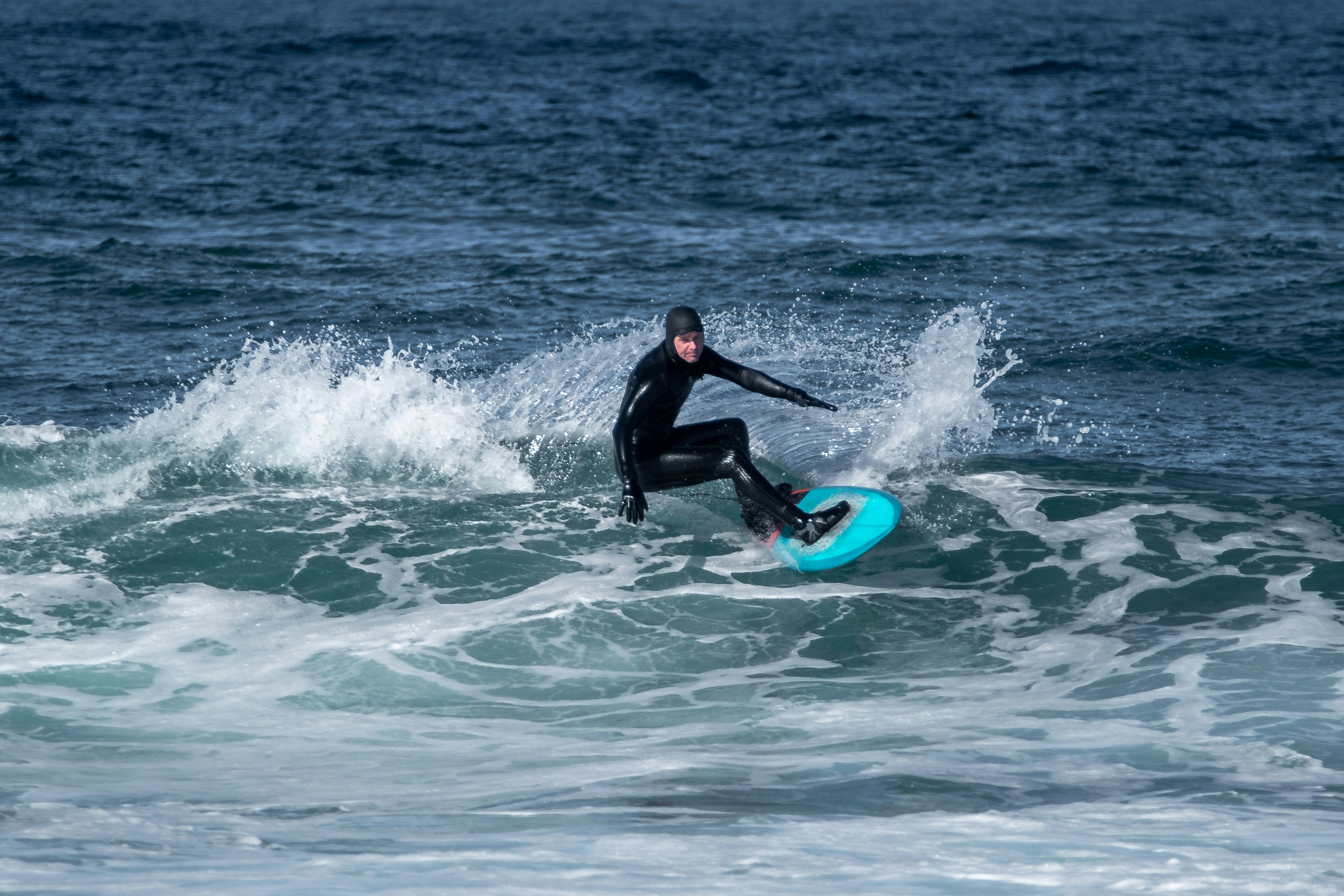 a man riding a wave on top of a surfboard