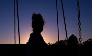 A sunset silhouette of a golfer swinging against a colorful sky backdrop