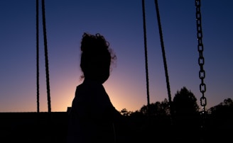 A sunset silhouette of a golfer swinging against a colorful sky backdrop