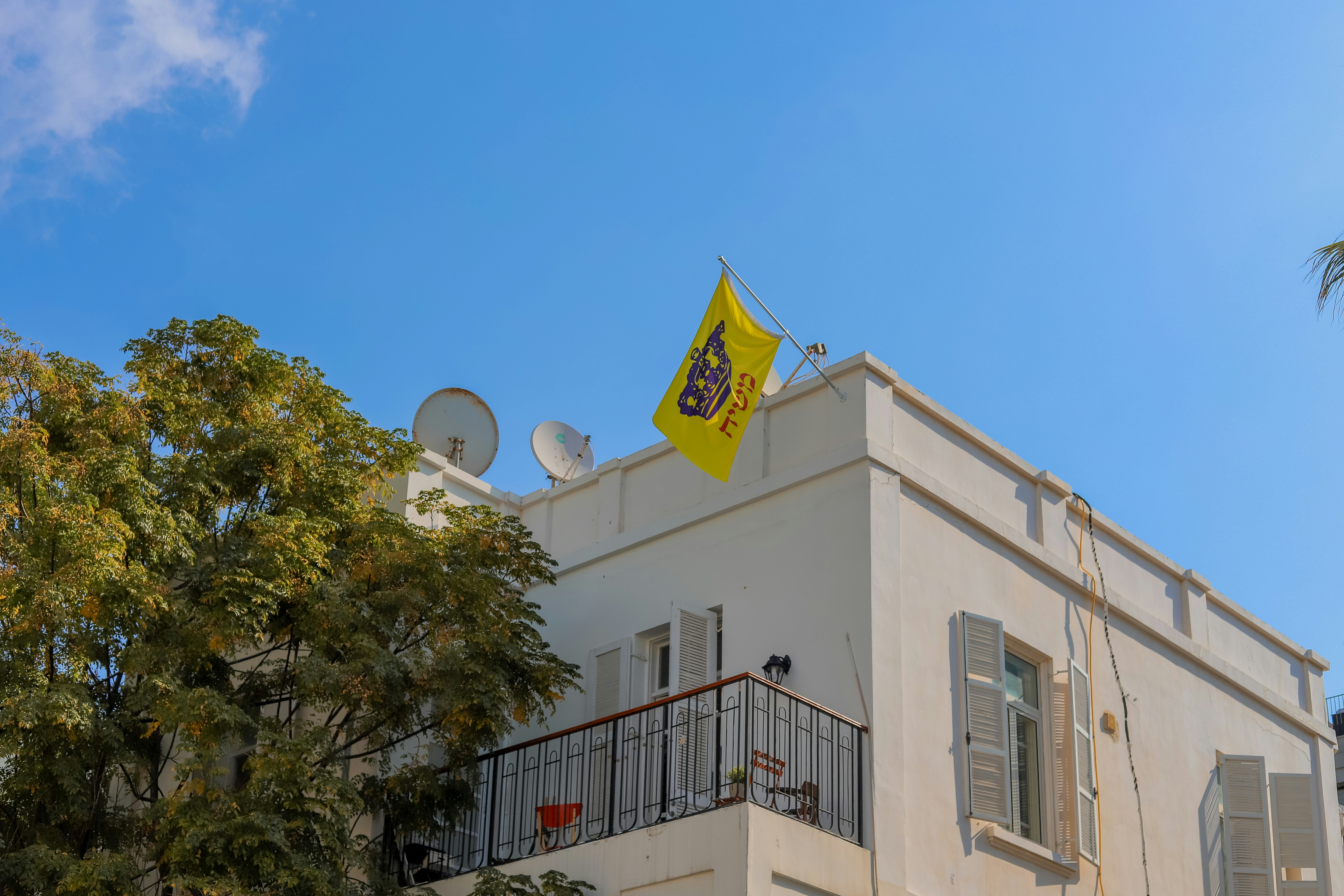 a white building with a yellow flag on top of it