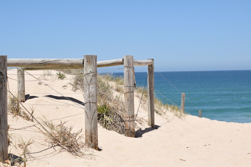 a wooden gate on a sandy beach near the ocean