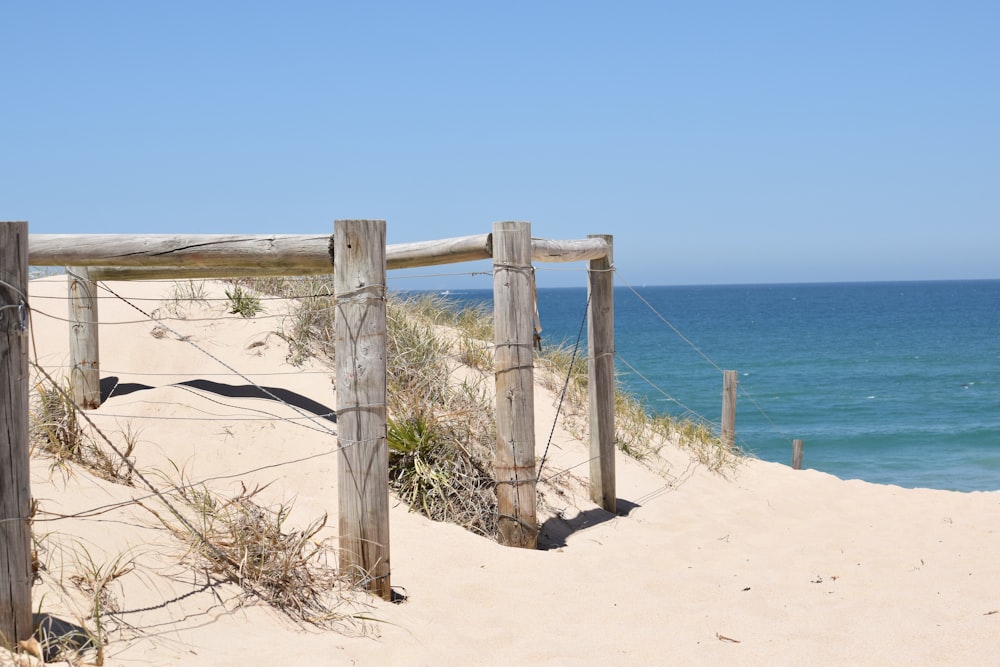 Ein Holztor an einem Sandstrand in der Nähe des Ozeans