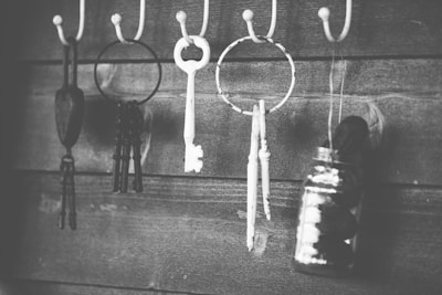 Close-up of a brownv key hanger with keys and small accessories hanging in an inviting hallway.