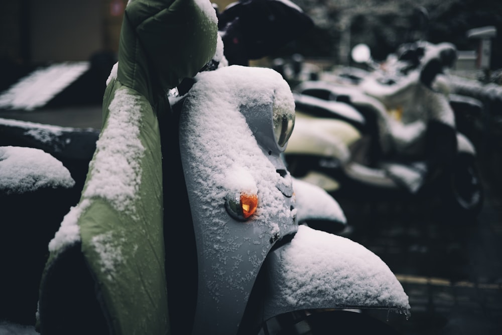 a parking meter covered in snow next to parked motorcycles