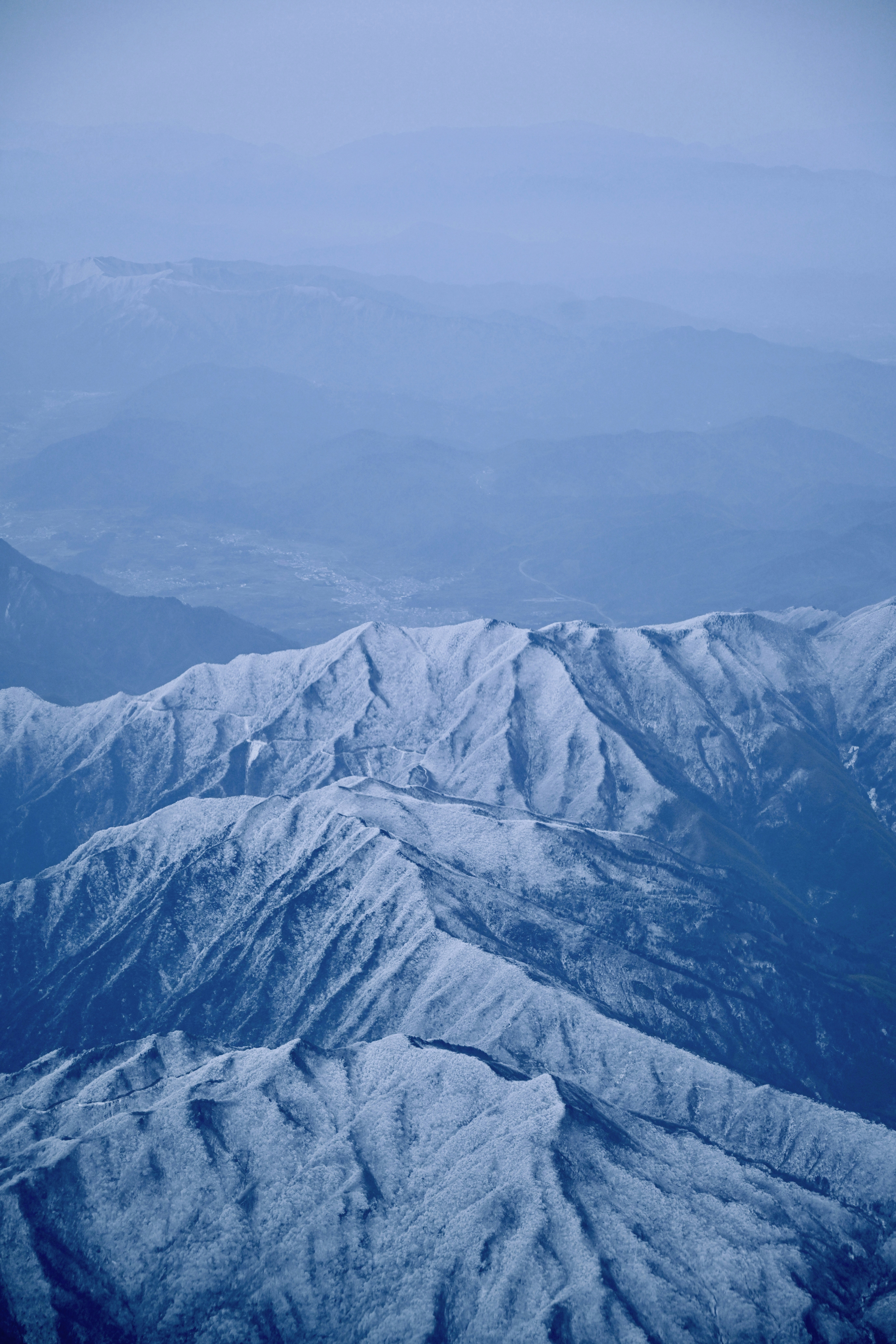 A view of a snowy mountain range from an airplane