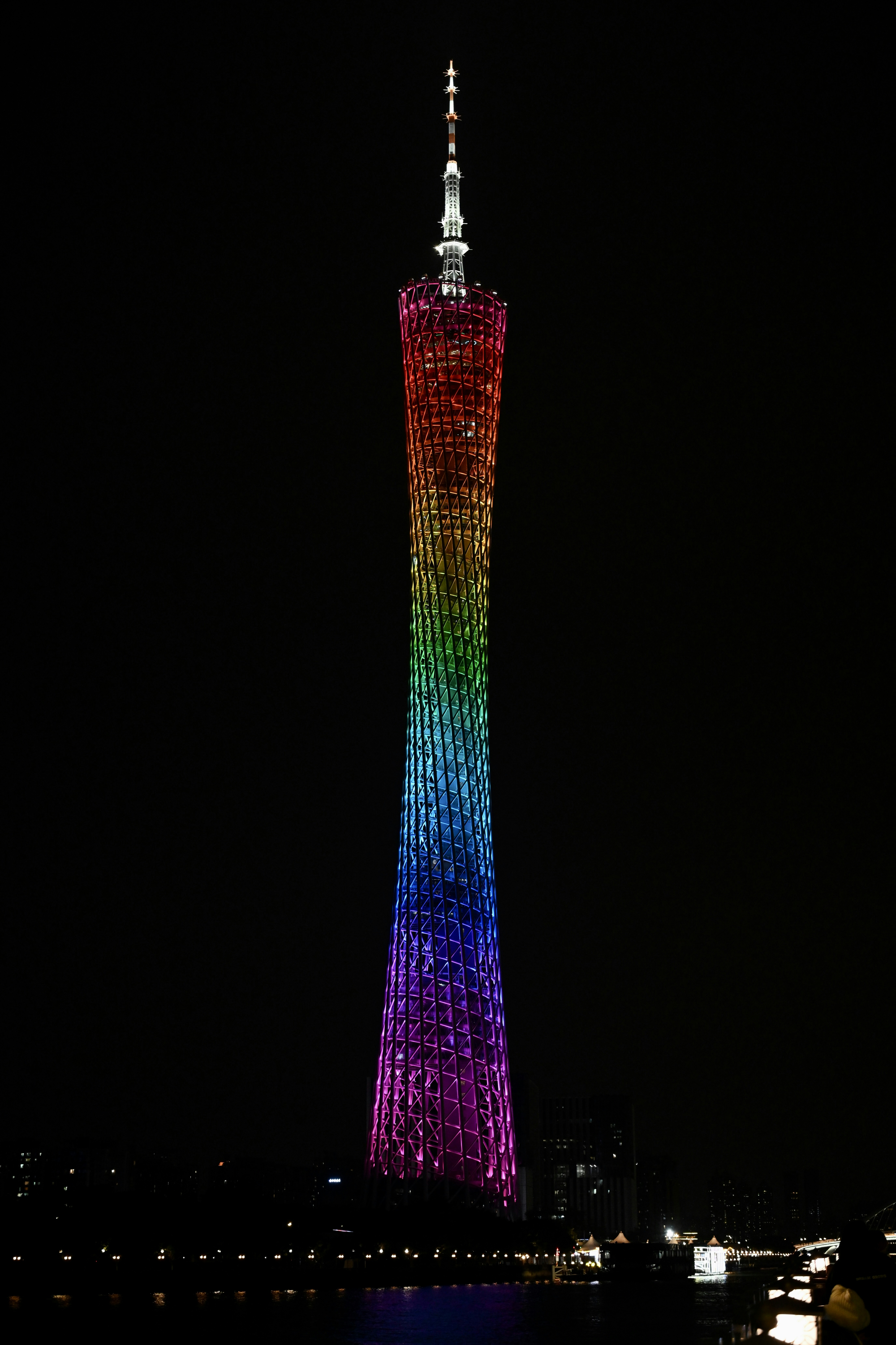 A very tall building with a very colorful light on it's side