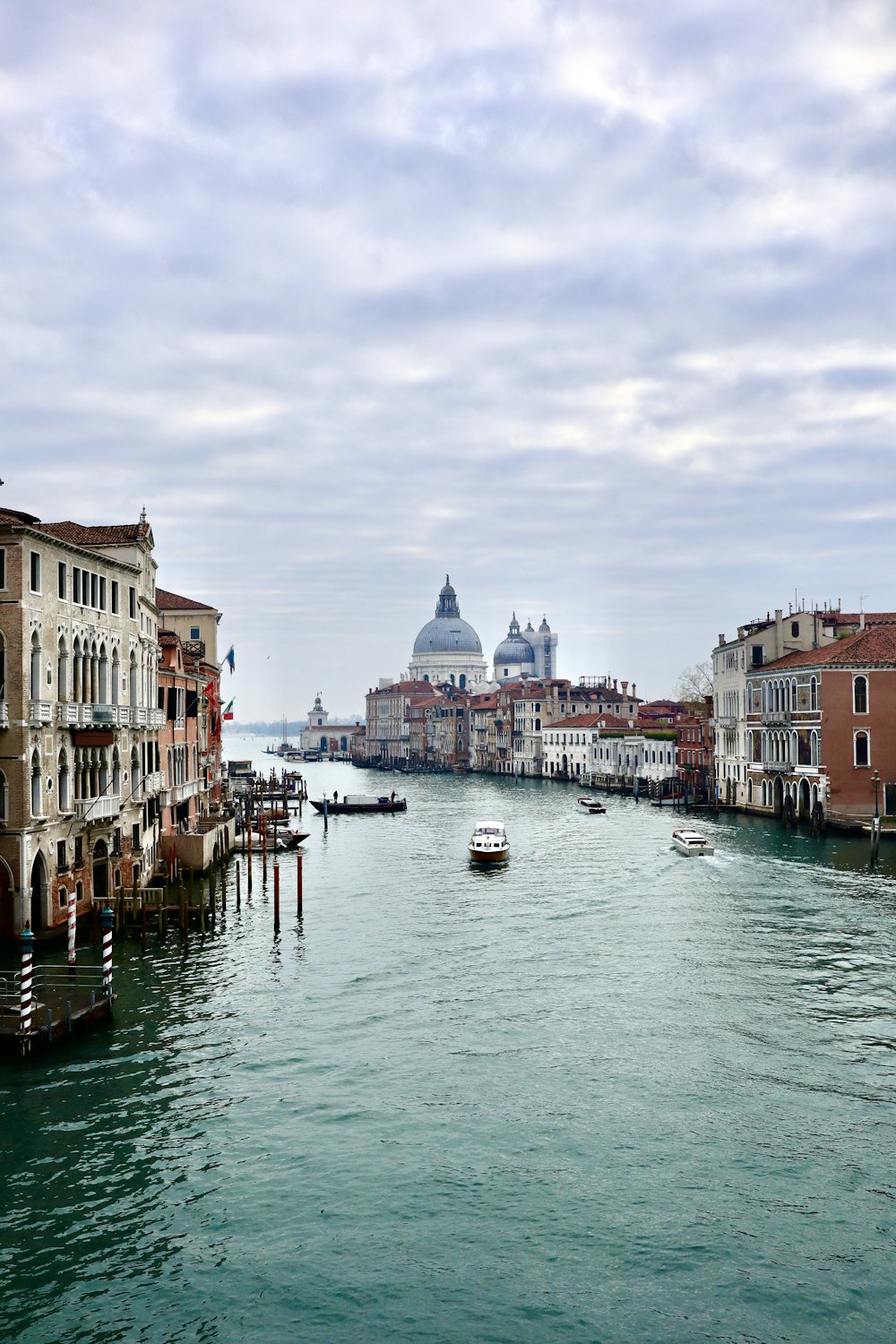 a view of a canal with buildings and a dome in the background