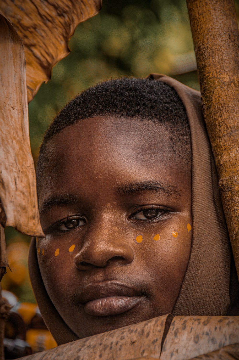 a young boy with yellow dots on his face