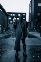 A shadowy figure in a trench coat, lurking in an urban alley.