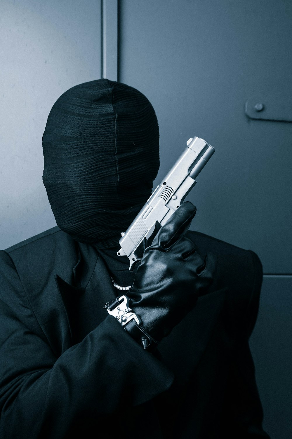 a man in a black suit holding a gun