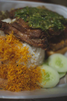 A colorful plate of jerk chicken with rice and peas, garnished with fresh herbs.
