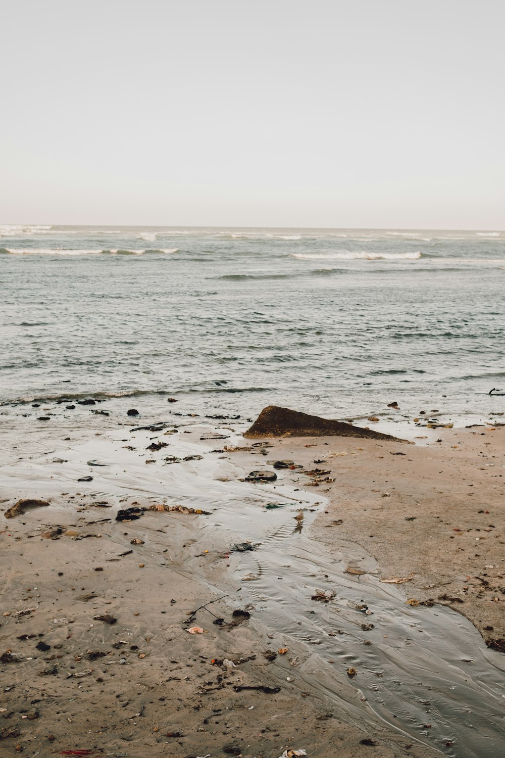 a person walking on a beach with a surfboard