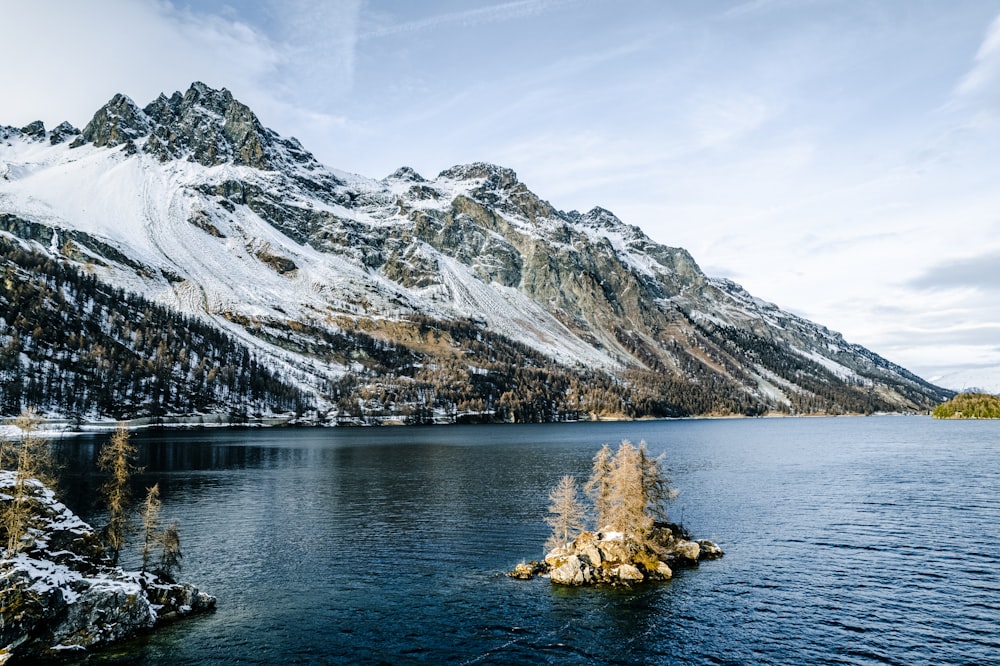 a lake surrounded by mountains covered in snow