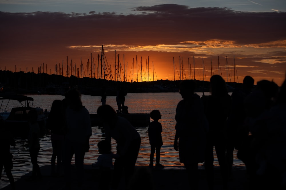 a group of people standing next to a body of water