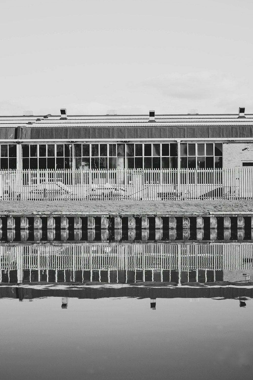 Una foto in bianco e nero di un edificio accanto a uno specchio d'acqua