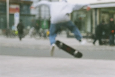 A professional shortboard mid-air during a street trick, cityscape blurred in background.