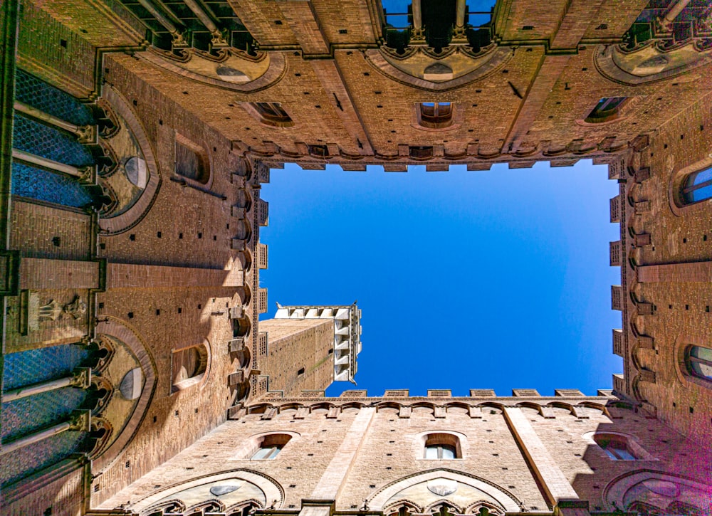 looking up at a tall building with a blue sky in the background