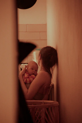 Cozy setting of a lactation consultant offering gentle support to a new mother.