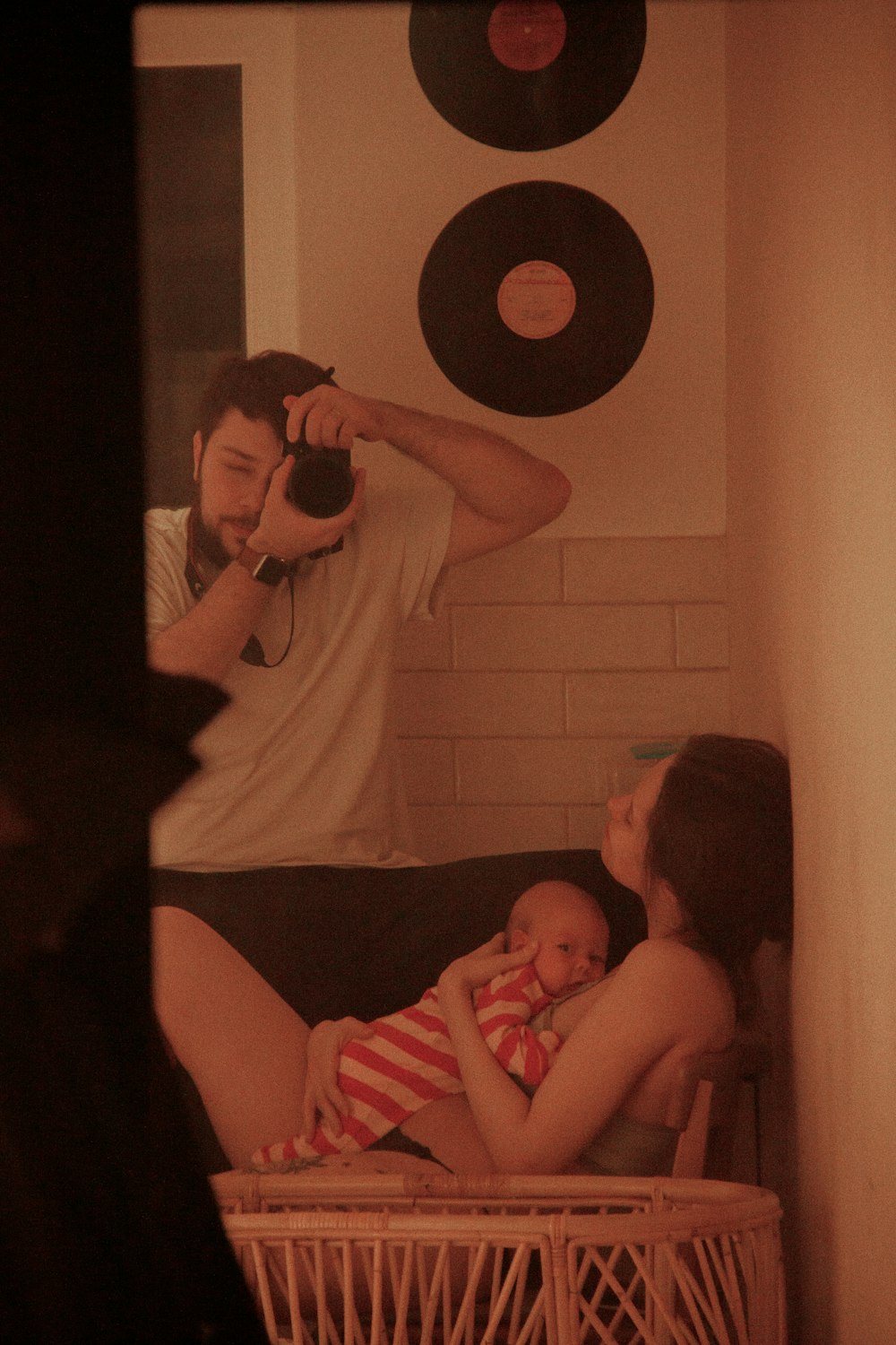 a man taking a picture of a woman holding a baby