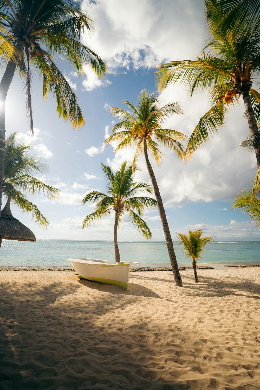 a white boat sitting on top of a sandy beach