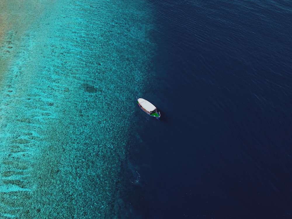 una piccola barca che galleggia sopra uno specchio d'acqua